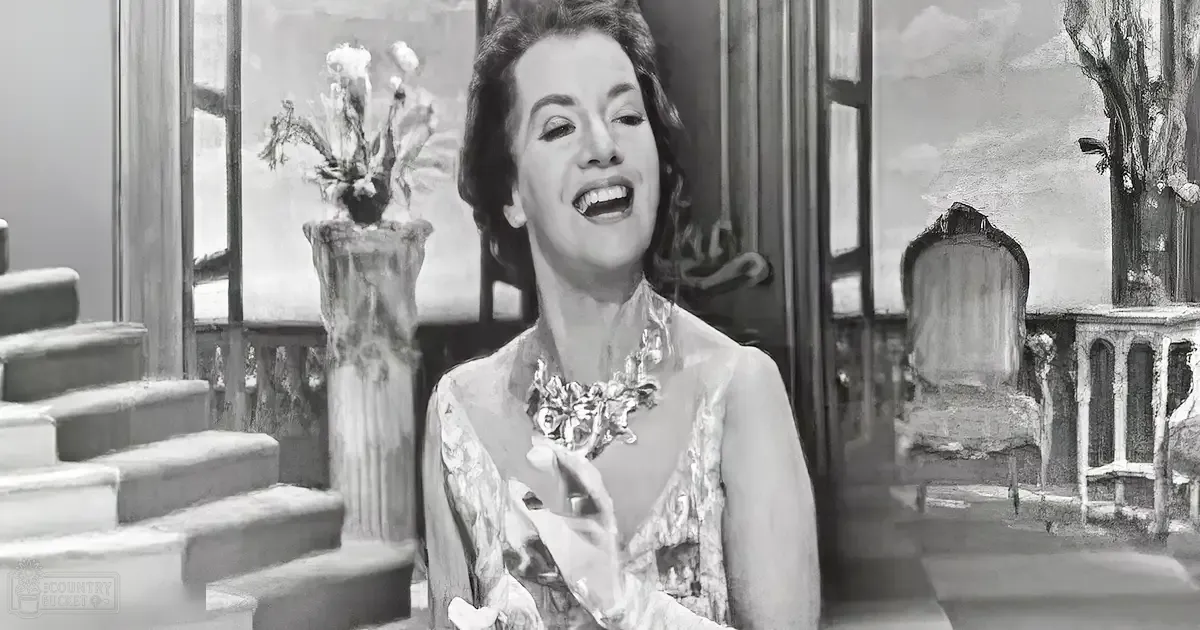 An adult female in an indoor setting with classical decor elements, wearing a sleeveless floral-patterned garment from the mid-20th century style.