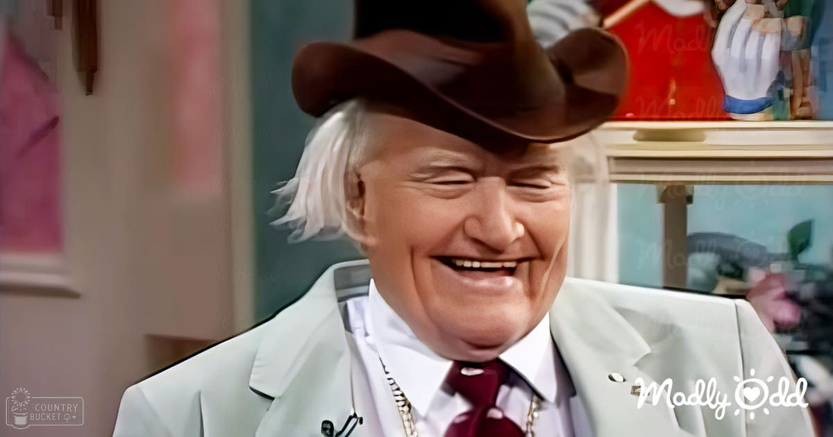 An older adult male in a domestic setting, wearing a white suit jacket with a lapel pin and maroon tie. The background includes shelves with various items and framed artwork.
