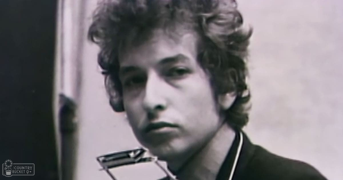 A young adult male wearing a 1960s-style jacket indoors; light-colored shirt visible beneath it.