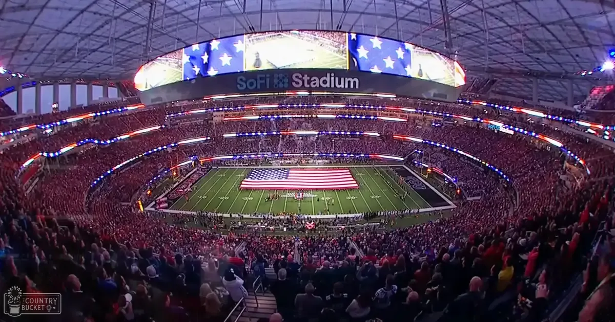 A large indoor stadium packed with spectators, illuminated by artificial lights at either evening or night; the season appears to be fall or winter based on attire and absence of leaves.