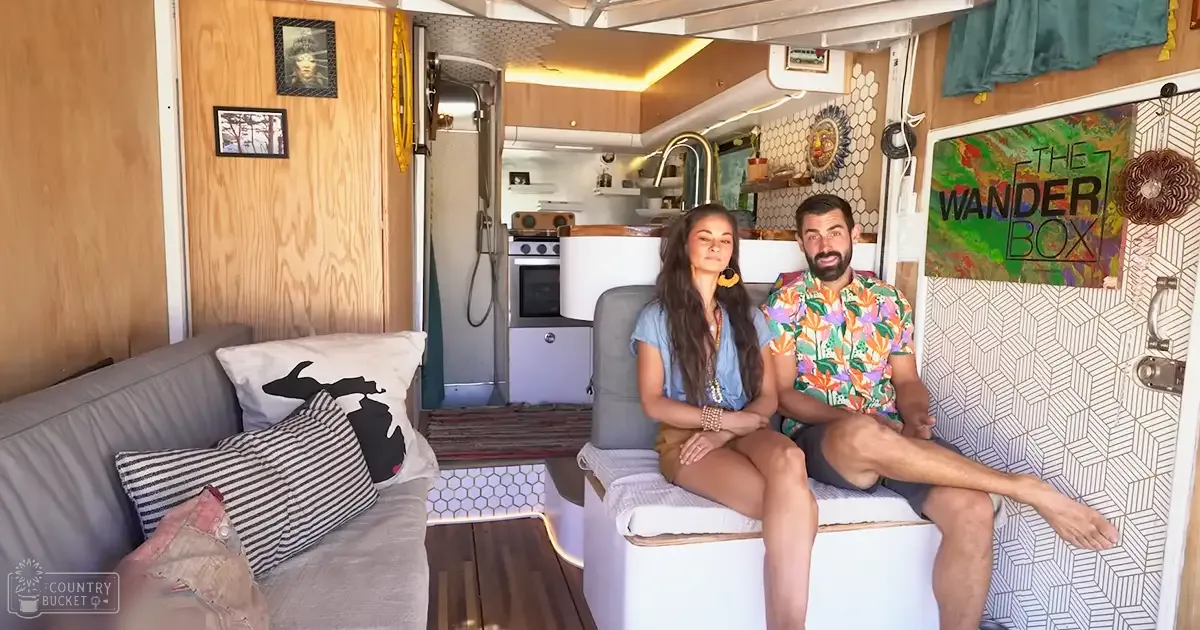 A young adult female and an adult male in a cozy RV interior, wearing casual summer attire with a relaxed fit and floral patterns respectively.
