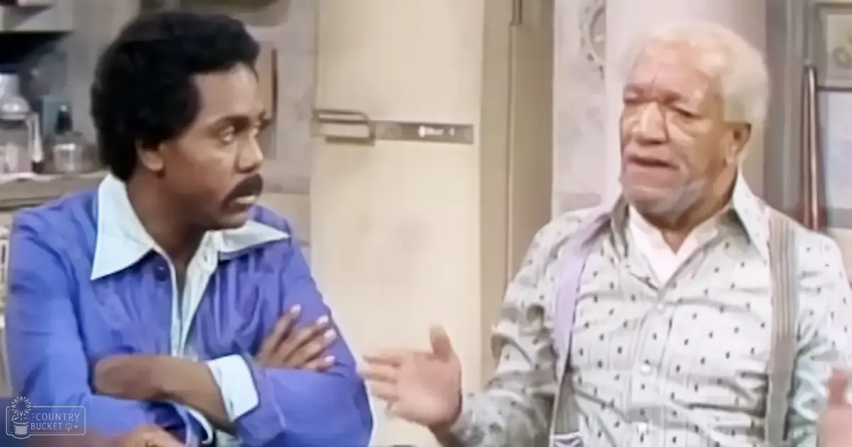 Two individuals in a professional indoor setting, engaging in conversation; one wearing a blue jacket with white collars, the other an older adult male in a light-colored polka dot shirt and glasses.