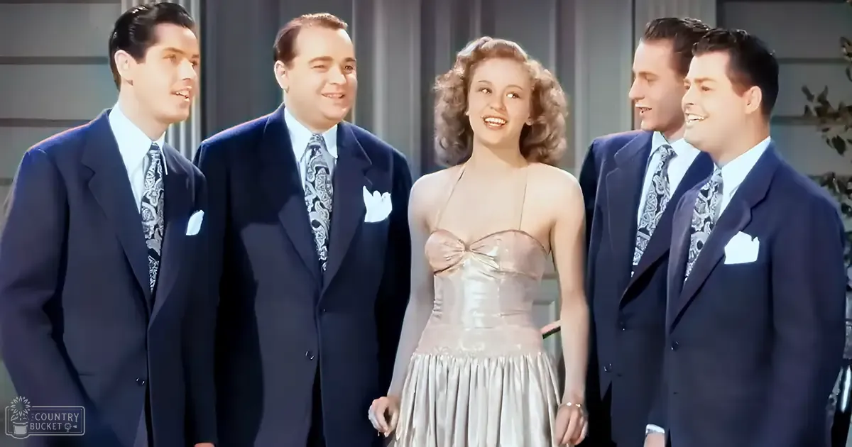 Young adults in formal attire gather indoors at what appears to be a party or formal event, with a focus on elegant clothing and social interaction.