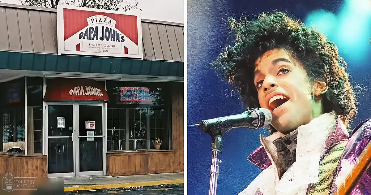 A young adult male singer wearing a shiny, colorful 1980s-style jacket performs outside of a Papa John's pizza restaurant under stage lighting with reflections and a blue hue in the background.
