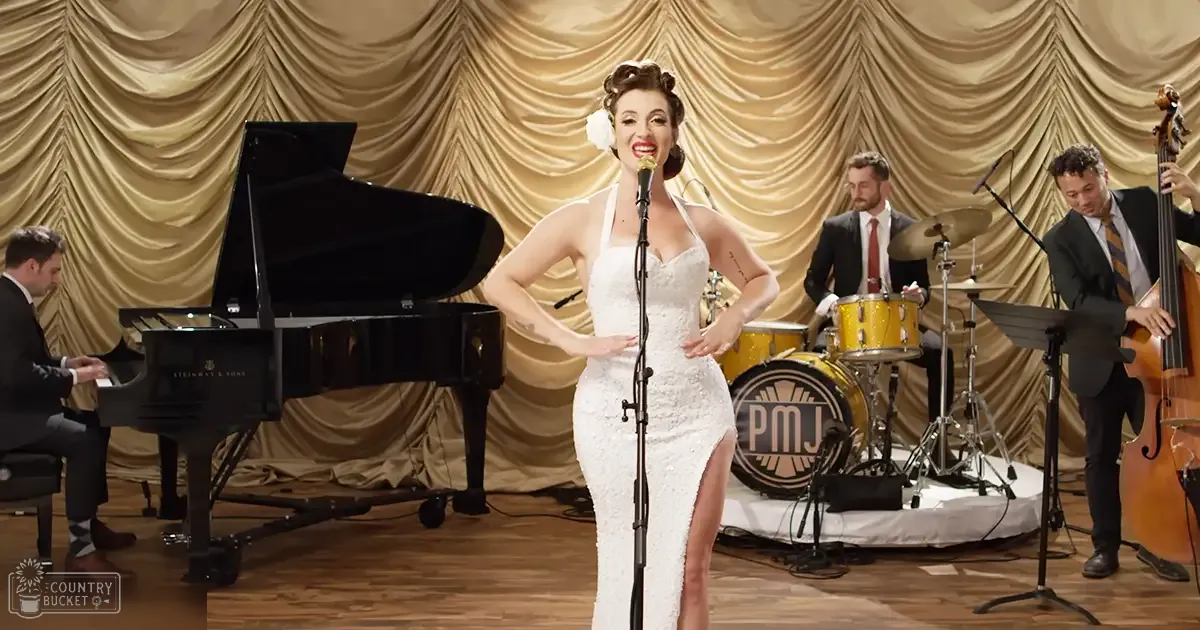 A woman in a white sequined dress sings on stage with musicians; the piano is Steinway & Sons brand.