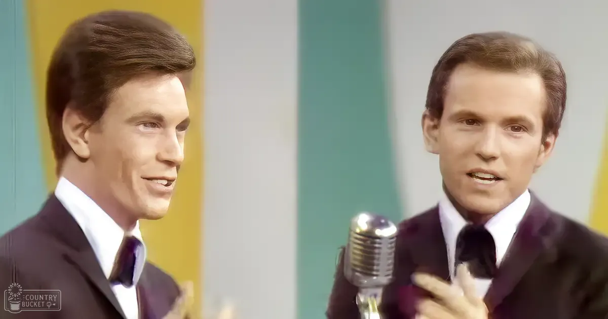 Two young adult males in formal attire stand before a vintage microphone in a brightly lit studio with teal and yellow panels.