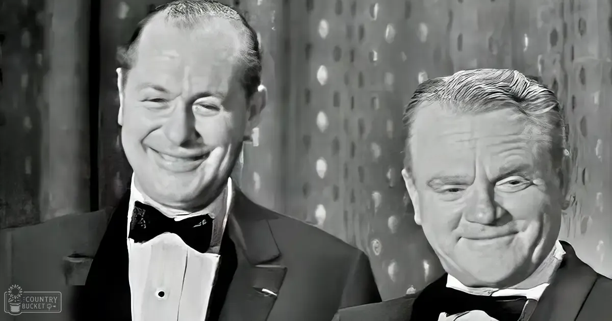 Two adult men dressed formally in a mid-20th-century indoor setting with textured wall and circular patterns, possibly at an event.