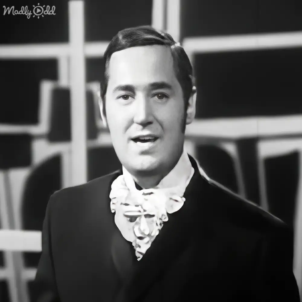 Young adult male in formal suit with ornate bow tie indoors against geometric backdrop