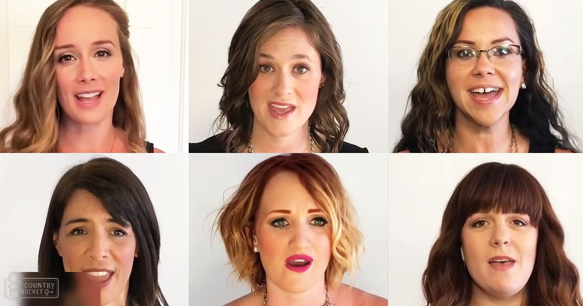 Six young adult females with various hairstyles and tops indoors against plain white walls during daytime.