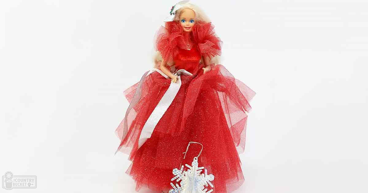 A single doll dressed in an elaborate red gown with ruffled sleeves against a plain white background.