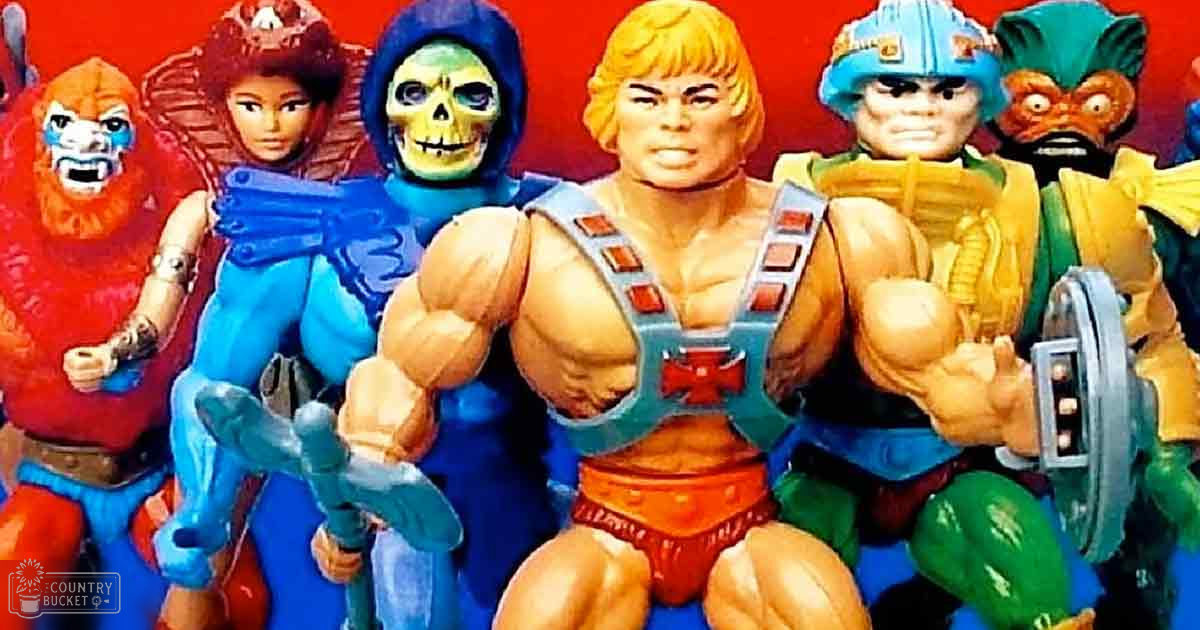 A collection of 'He-Man and the Masters of the Universe' action figures posed against a plain red backdrop in what appears to be a studio setting, likely from the 1980s.