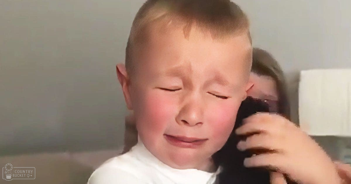 A toddler wearing a simple white t-shirt indoors with soft lighting.