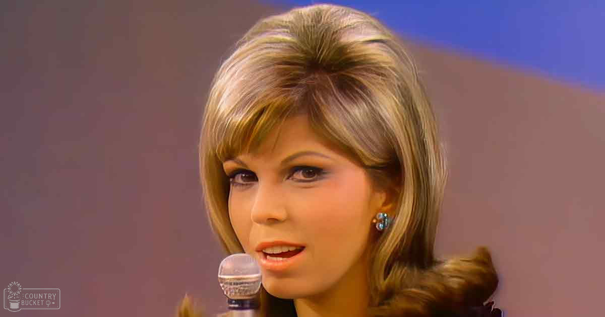 A young adult female wearing small earrings and holding a microphone, with 'Madly Didd' branding in the corner against an indoor backdrop with blue and brown gradients.