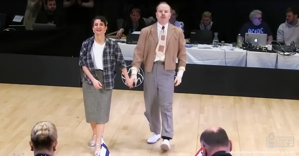 Adults in a fashion show setting, one wearing a plaid shirt over a white top with knee-length pencil skirt and silver high-heeled shoes; another in beige blazer over patterned tie and gray trousers with white sneakers.