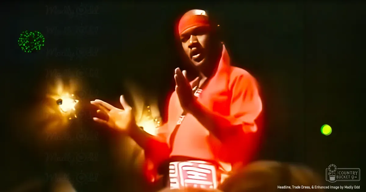 A performer on stage wearing a red shirt with white patterns, possibly at an event or concert.