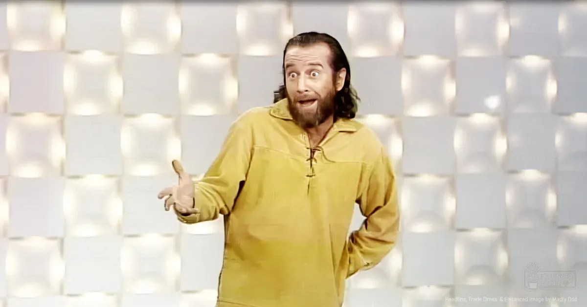 Adult male in a mustard-yellow long-sleeved, high-collared, laced-up front shirt with full-length sleeves and casual style indoors.