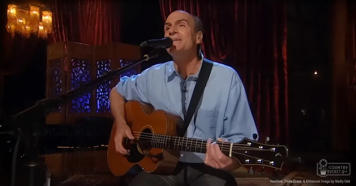 A middle-aged man singing into a microphone on stage with red curtains and decorative lighting, suggesting an indoor venue for performances.
