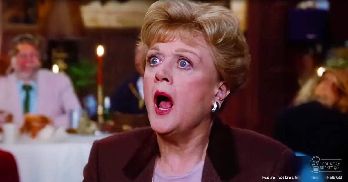 A middle-aged woman in a cozy indoor restaurant setting with warm lighting, wearing a dark brown blazer over a white top and small hoop earrings.