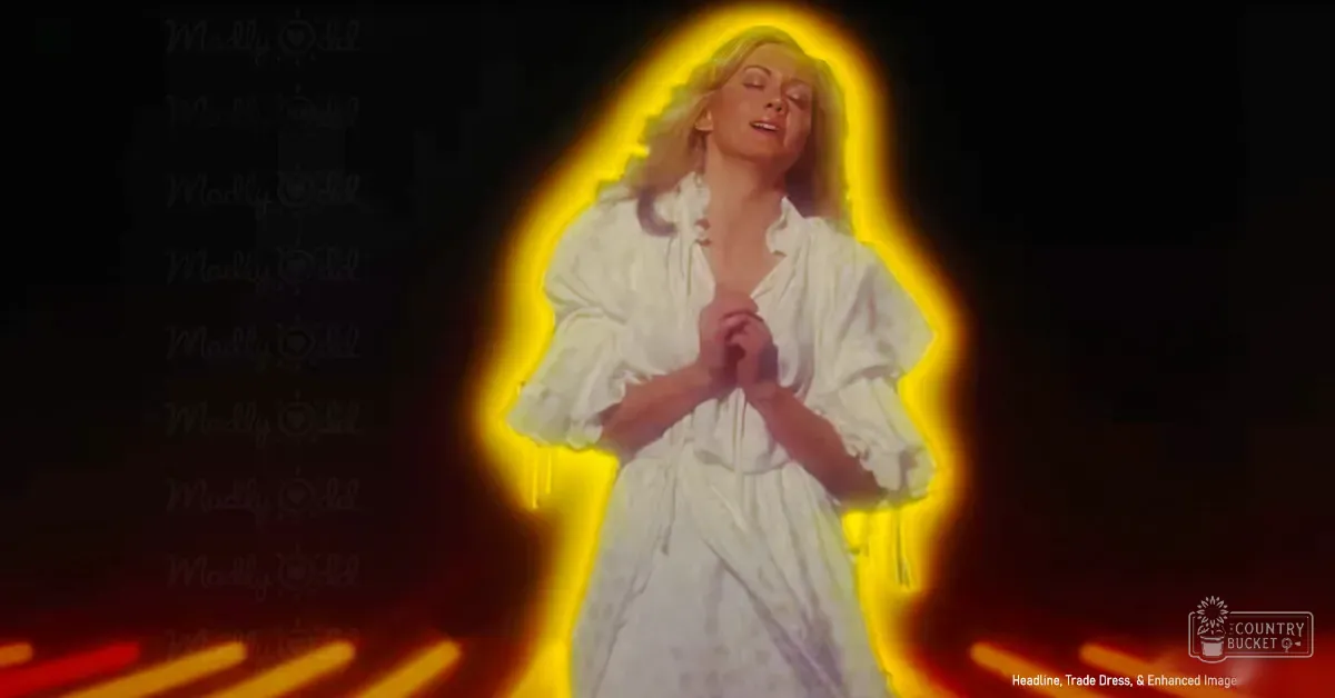 An adult female in a white blouse with puffed sleeves and a tie, glowing yellow aura on stage, dark red-orange streaked background