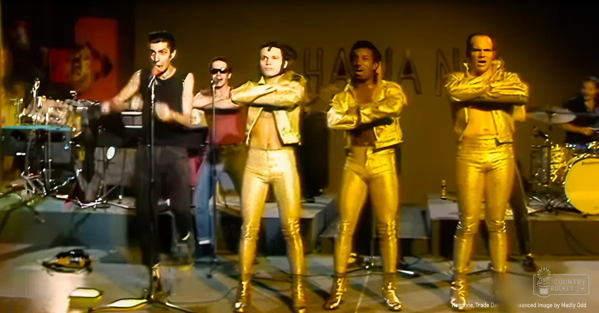 A performance group in gold outfits at a music venue with musical instruments on stage.