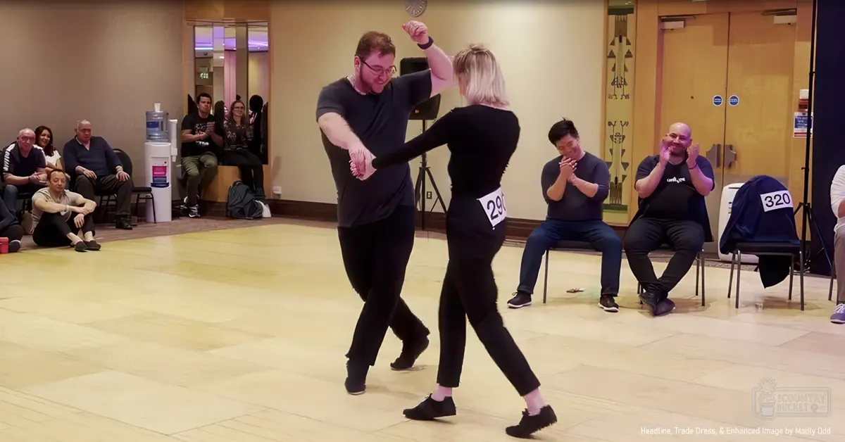 Dance pair in an indoor dance hall during a practice or competition session; spectators in the background;