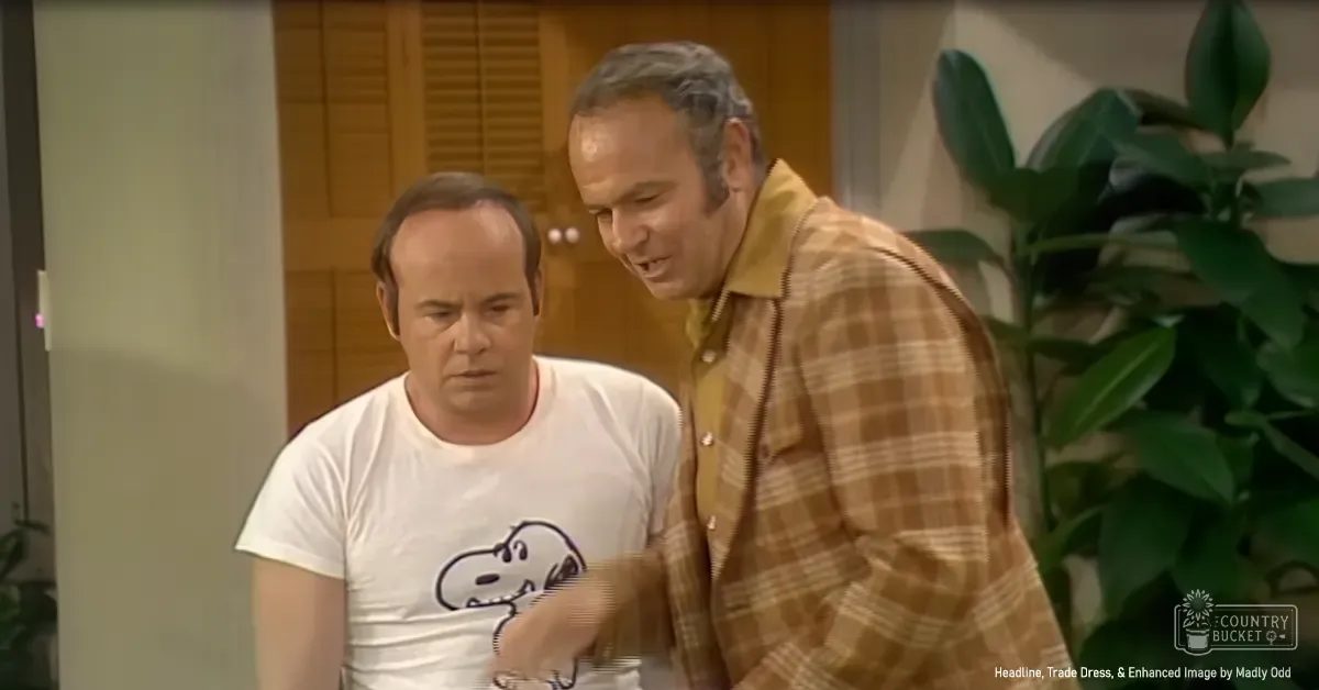 Middle-aged men in a casual indoor setting with wooden furniture and greenery, light suggesting daytime natural light.