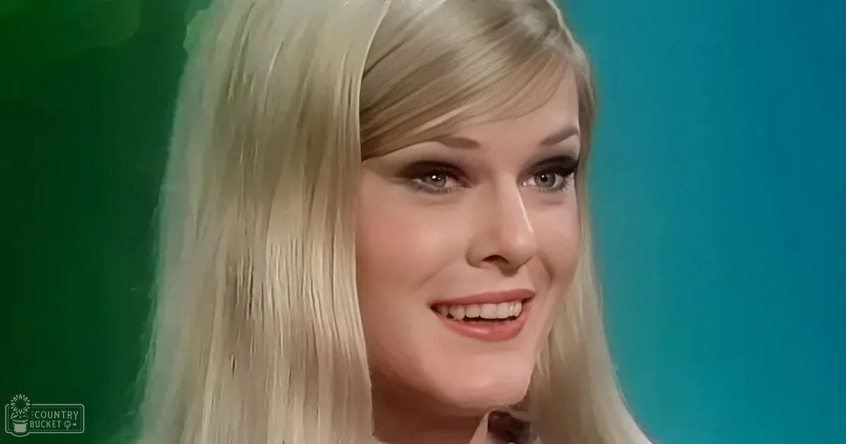 Blonde woman with long hair smiling, green and blue background.