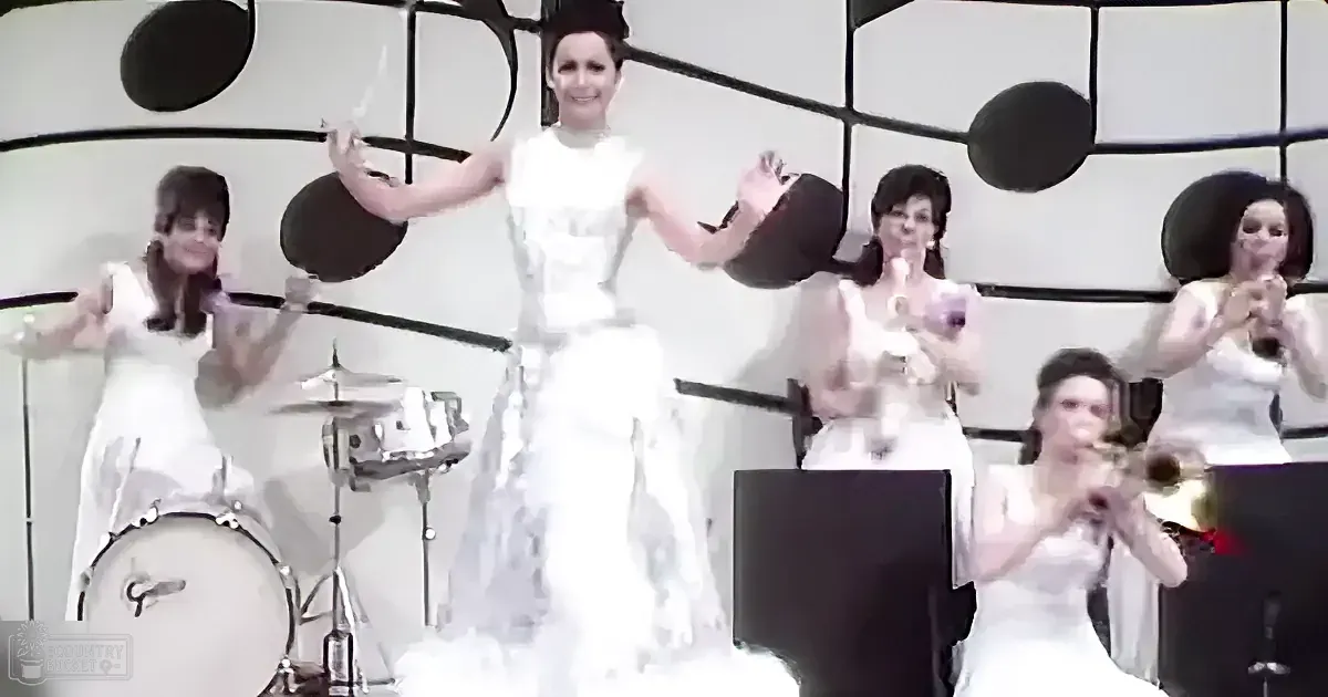 A bride in a white dress is surrounded by musicians in white outfits, playing instruments.