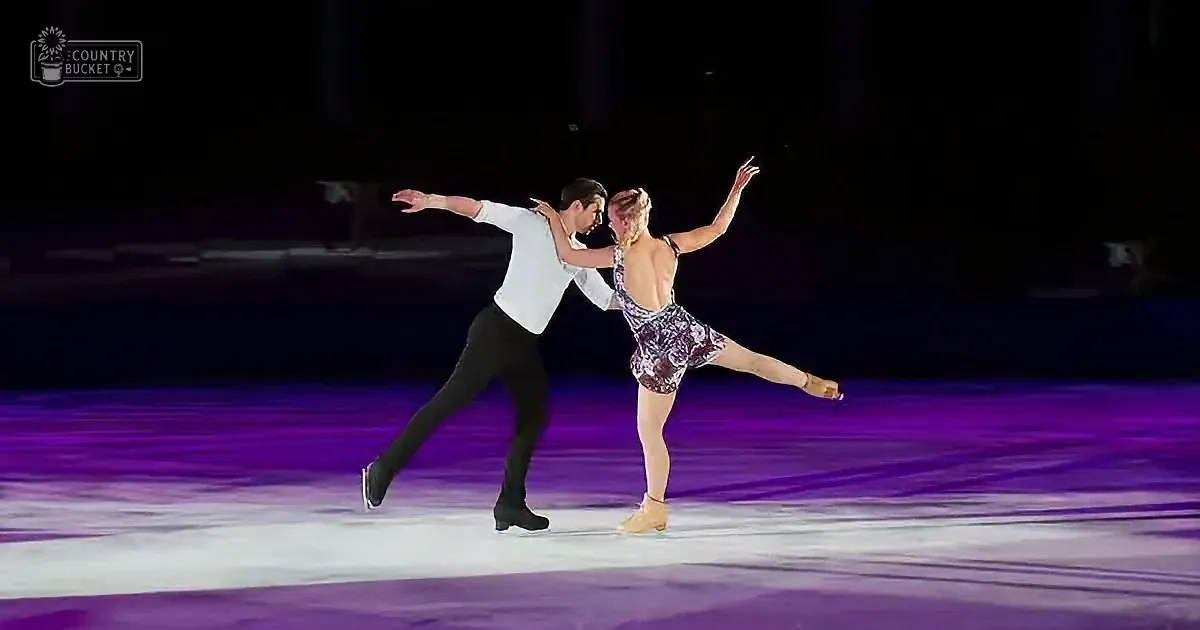A couple in a graceful skating pose on a purple-lit ice rink.