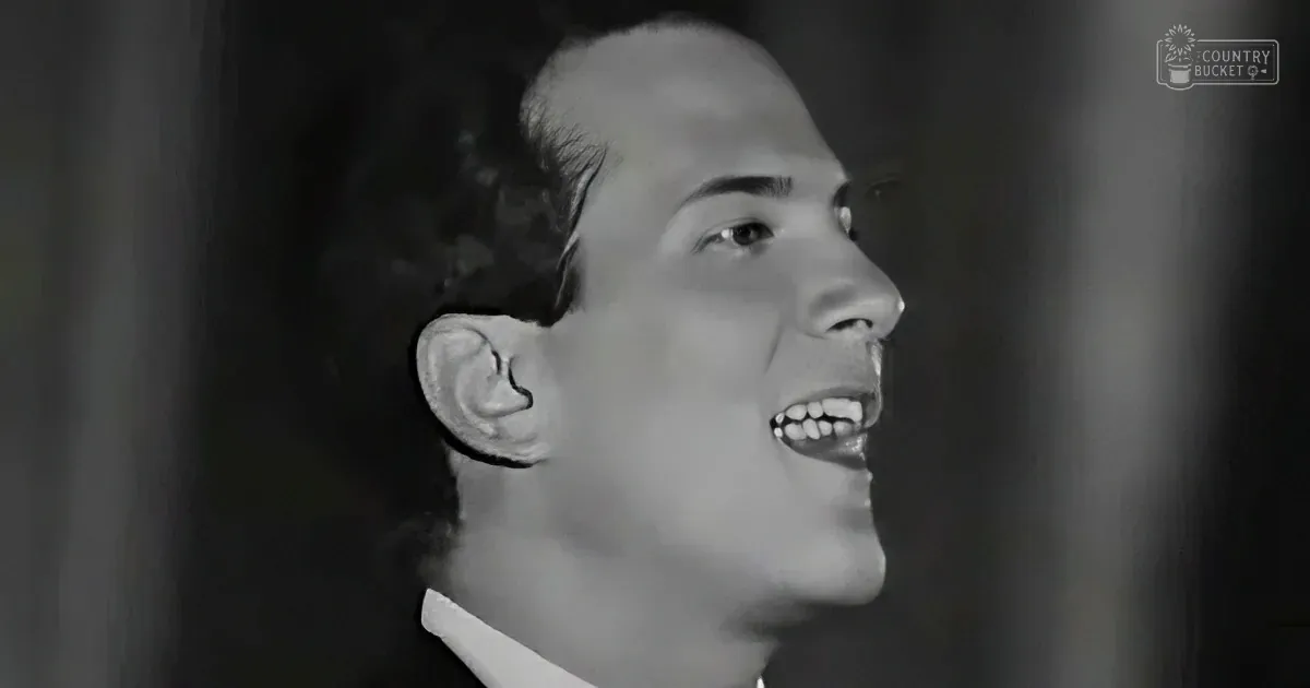 A man with a receding hairline and a white shirt is smiling and looking upwards.