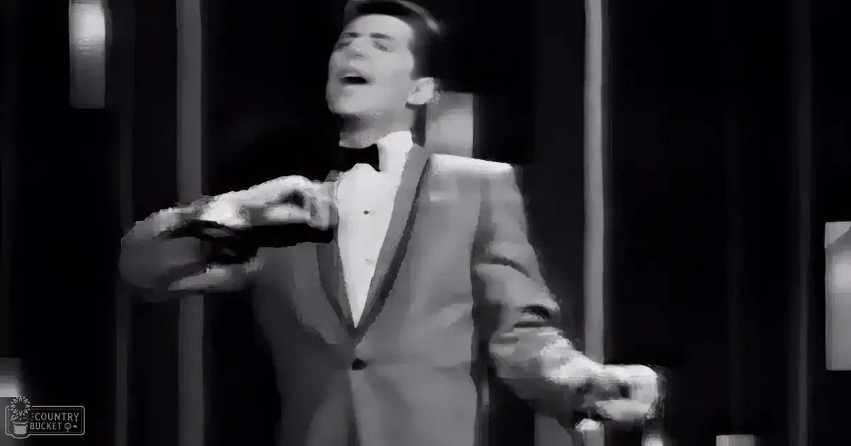 A man in a suit and bow tie is singing passionately, holding a microphone.