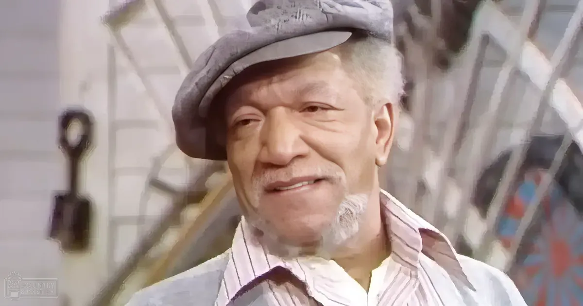 An older man wearing a flat cap and striped shirt smiles, with a blurred background of a house and ladder.