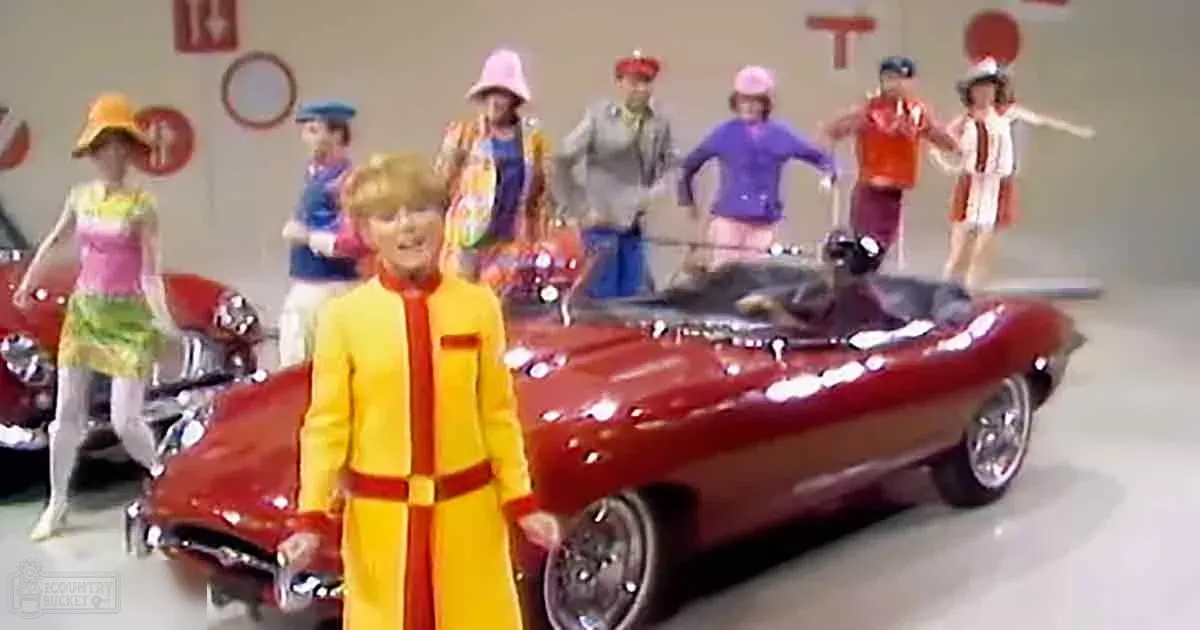 A person in a yellow outfit stands in front of a red convertible car, surrounded by other colorful figures.