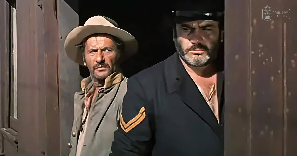Two men, one in a cowboy hat and the other in a military uniform, stand side by side, looking serious.