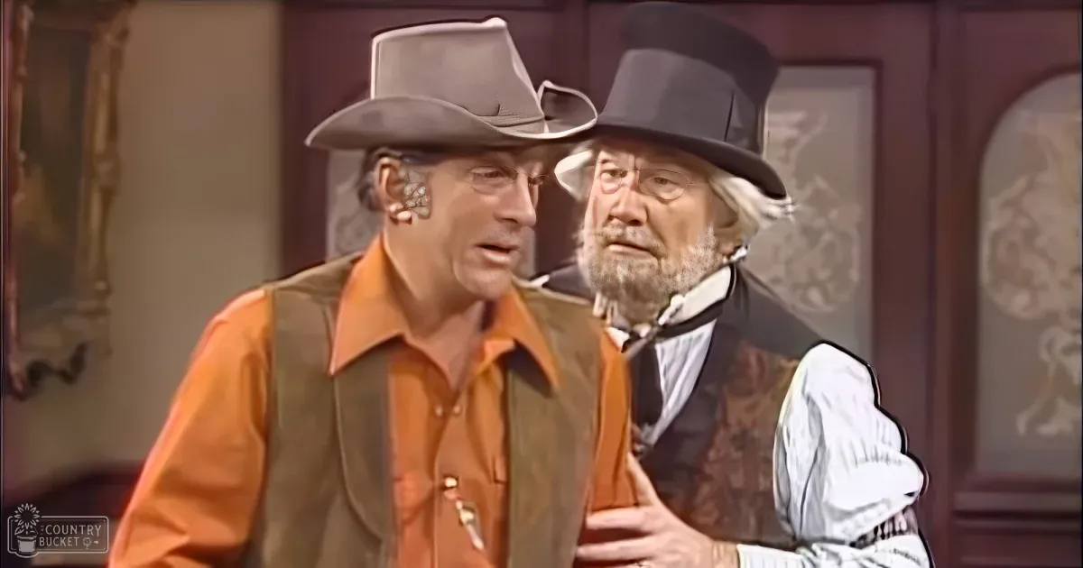Two men in vintage attire, one in a cowboy hat and the other in a top hat, appear to be in a dramatic or comedic scene.