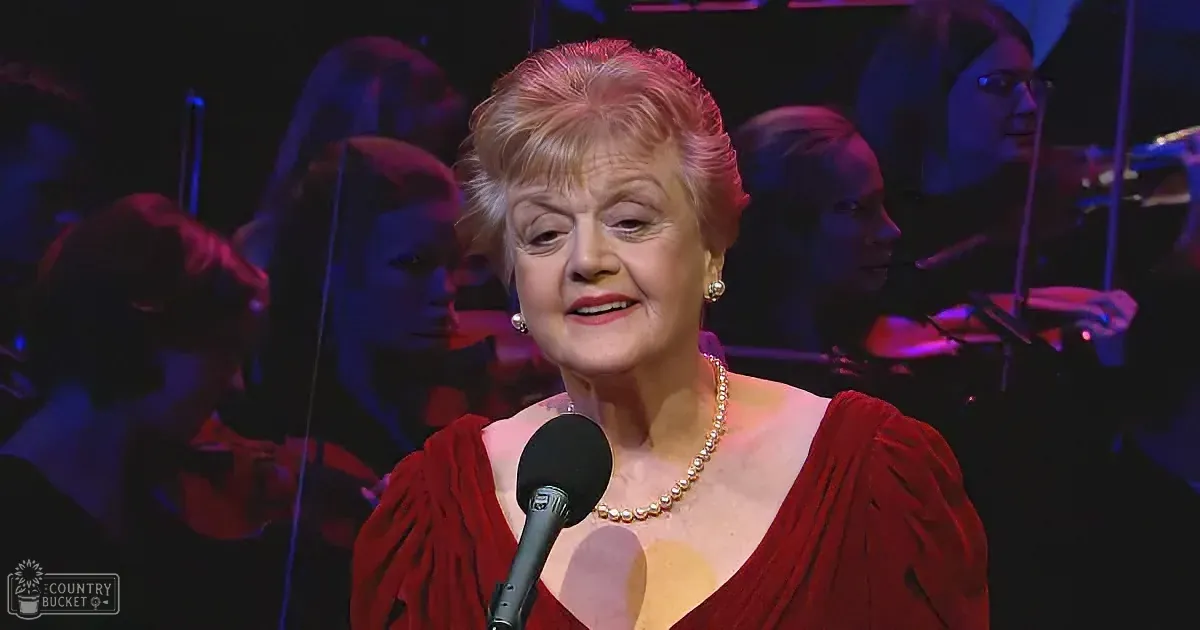 A woman in a red dress sings into a microphone, surrounded by musicians in a dimly lit setting.